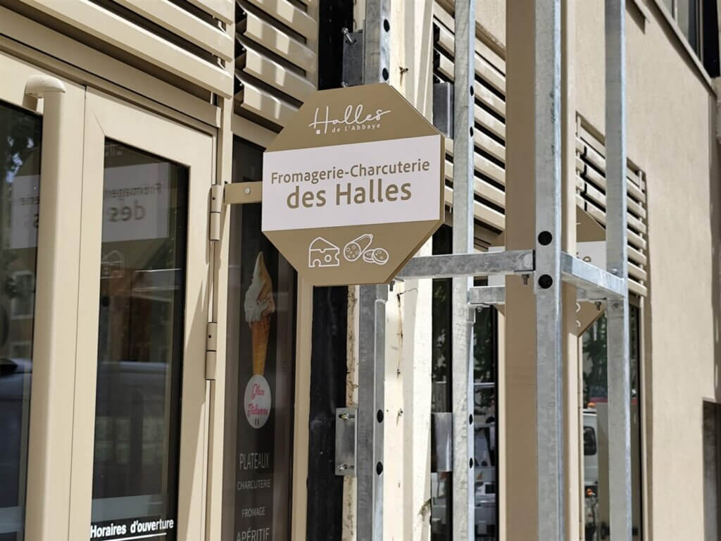 Enseigne drapeau d'un commerçant des Halles de l'Abbaye à Alès